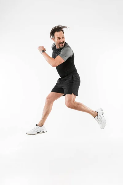 Красивый концентрированный взрослый спортсмен бежит — стоковое фото