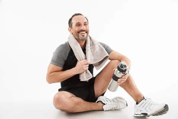 Riendo deportista maduro fuerte sentado con toalla y agua — Foto de Stock