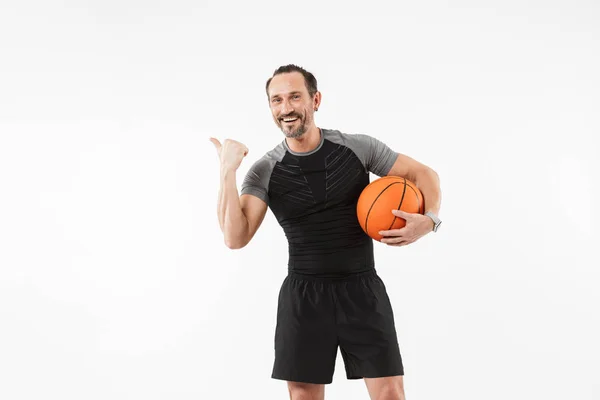 Retrato de un deportista maduro sonriente sosteniendo baloncesto — Foto de Stock