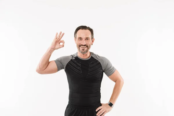 Portrait of pleased adult man fitness instructor smiling and ges — Stock Photo, Image