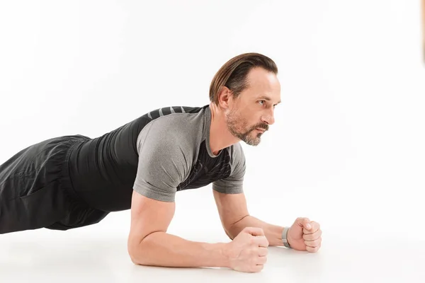 Adult man with beard and brown hair doing workout and making pla — Stock Photo, Image