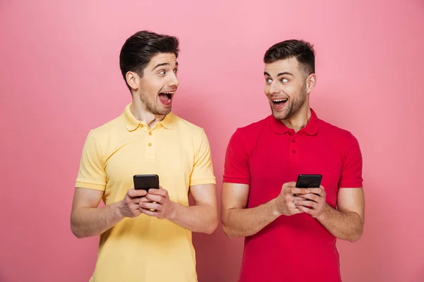 Portrait d'un couple gay heureux tenant des téléphones mobiles — Photo