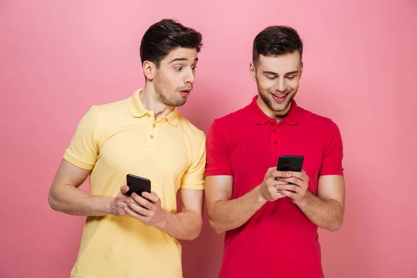 Portrait d'un couple gay excité utilisant des téléphones mobiles — Photo