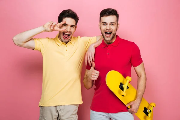 Portrait of a smiling gay male couple showing peace gesture — Stock Photo, Image