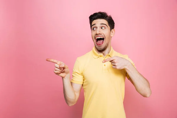 Porträt eines glücklichen jungen Mannes, der mit dem Finger wegzeigt — Stockfoto