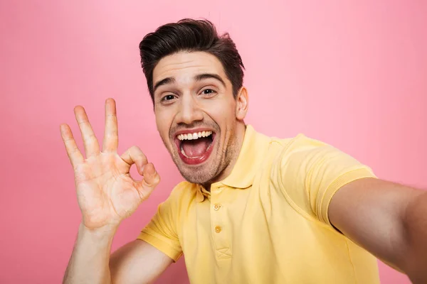 Retrato de um jovem feliz mostrando ok gesto — Fotografia de Stock