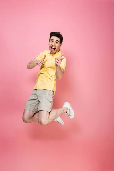 Full length portrait of an excited young man jumping — Stock Photo, Image