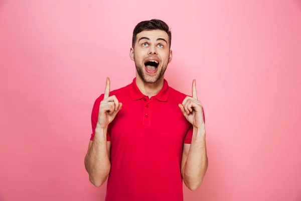 Retrato de um jovem alegre apontando os dedos para cima — Fotografia de Stock