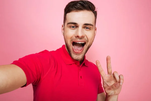 Retrato de un joven feliz mostrando un gesto de paz —  Fotos de Stock