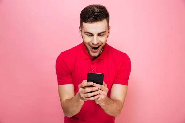 Porträtt av en lycklig ung man med hjälp av mobiltelefon — Stockfoto