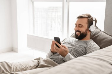 Temel giyim evde kanepe ve lis yalan sakallı adam 30'lu