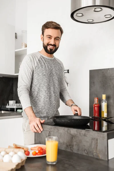 Attractive man with short brown hair and beard cooking alone bre — Stock Photo, Image