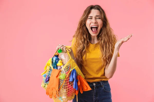 Foto di giovane donna arrabbiata che tiene la borsa con rifiuti di plastica e urla — Foto Stock