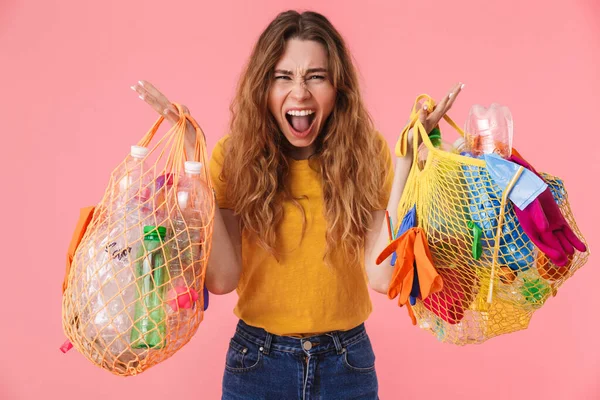 Foto de mujer furiosa sosteniendo bolsas con residuos de plástico y gritando — Foto de Stock