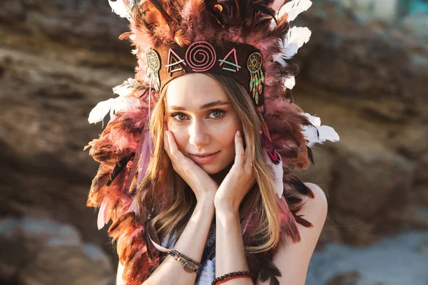 Image of hippy girl in indian chief feather headdress walking by