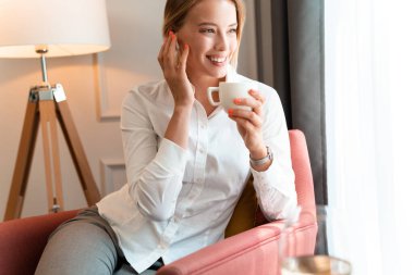 İşkadını kablosuz bluetooth kulaklık kullanıyor.