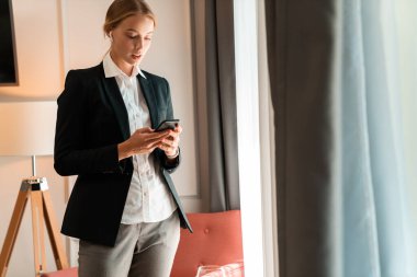 İçerideki iş kadını cep telefonu dinleme müziği kullanıyor.