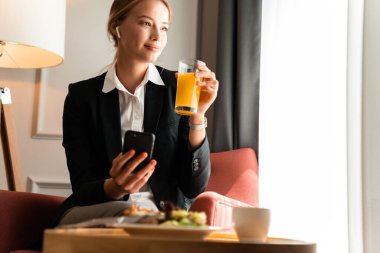 Sarışın iş kadını evde oturup yemek yiyor..