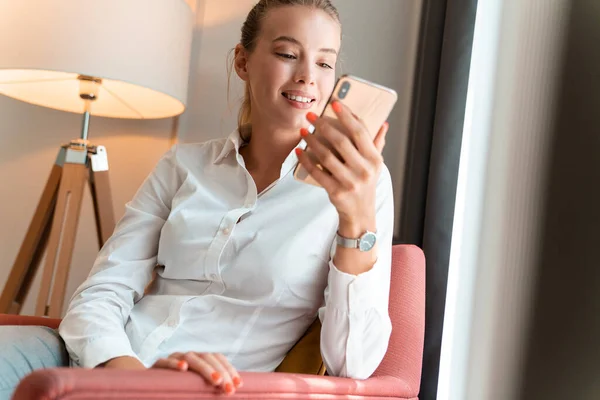 Jolie femme d'affaires blonde joyeuse s'asseoir à l'intérieur dans un café en utilisant un téléphone mobile . — Photo