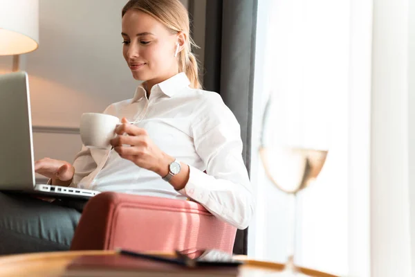 Pleased positive blonde business woman drinking coffee. — Stock Photo, Image