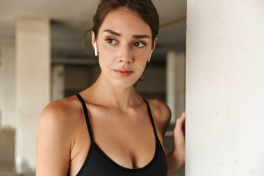 Kulaklıklarla müzik dinleyen memnun genç bir kadın görüntüsü