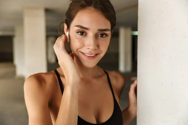 Image of pleased smiling woman listening music with earpods — Stock Photo, Image