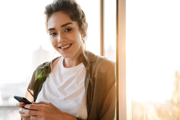 Imagen de mujer elegante sosteniendo teléfono inteligente en la terraza al aire libre — Foto de Stock