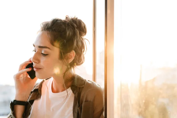 Imagen de una mujer encantadora hablando en smartphone en la terraza al aire libre — Foto de Stock