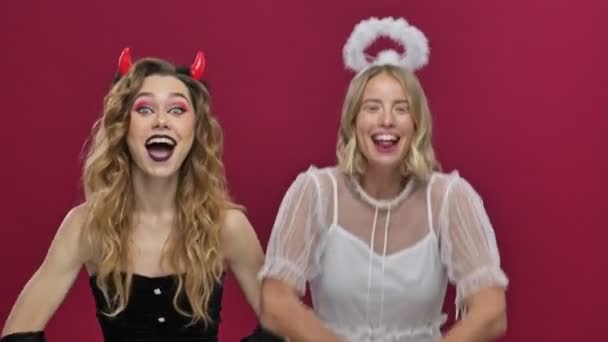 Glücklich Lächelnde Engel Und Dämonenmädchen Werfen Konfetti Und Tanzen Karnevalskostümen — Stockvideo