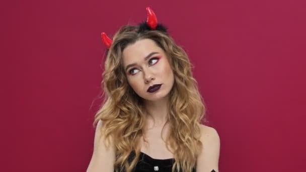 動揺悪魔女性でカーニバルの衣装ショー恨みでジェスチャーで隔離された以上の赤い壁の背景 — ストック動画