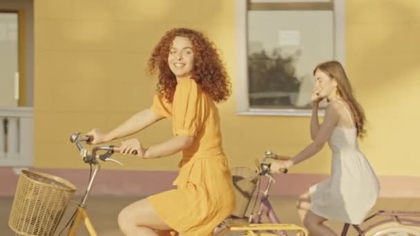 Cheerful Beautiful Young Girls Friends Smiling While Riding Bicycles Outdoors — Stockvideo