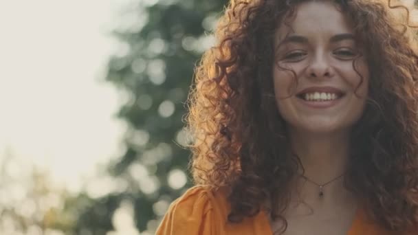 Turuncu Elbiseli Komik Kızıl Saçlı Kadın Parkta Dikilirken Gülümsüyor Saçlarını — Stok video