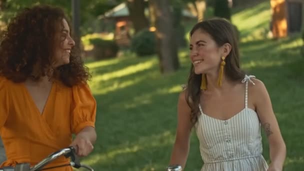 Happy Beautiful Young Girls Friends Smiling Laughing While Walking Bicycles — Stockvideo