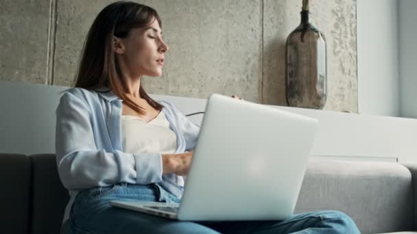 Düşünceli Genç Kadını Gözlüğünü Çıkarıp Dizüstü Bilgisayarda Çalışırken Pencereye Bakıyor — Stok video