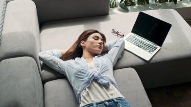 Büyüleyici genç bir iş kadınının evdeki kanepede yatarken uyanıp uyumasının en iyi görüntüsü.