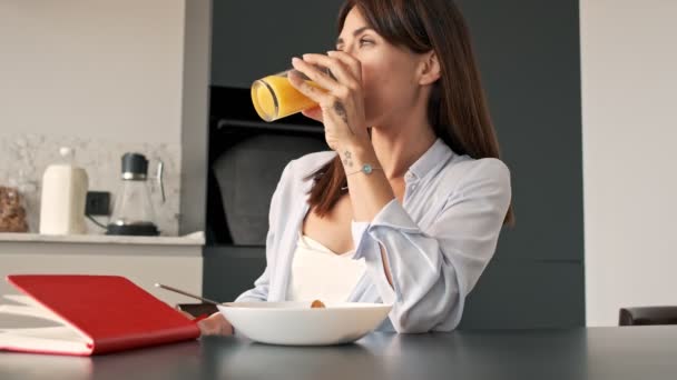 Nachdenkliche Hübsche Junge Frau Trinkt Orangensaft Während Sie Morgens Der — Stockvideo