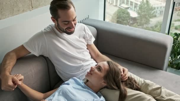 Encantadora Joven Pareja Encantadora Sonriendo Hablando Mientras Relaja Sofá Casa — Vídeos de Stock