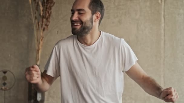 幸せな若いブルネットの男は笑顔で踊りながら家で楽しみながら — ストック動画