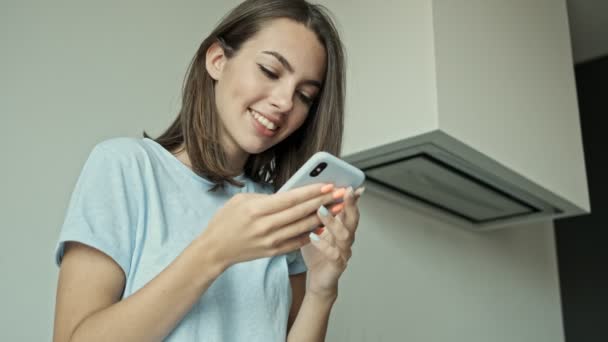 Atraktivní Šťastná Mladá Brunetka Žena Chatování Smartphone Pití Džus Zatímco — Stock video