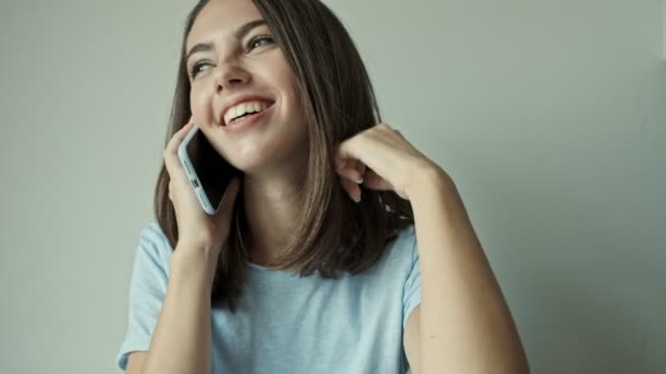 Feliz Joven Morena Sonriendo Hablando Teléfono Inteligente Mientras Sienta Casa — Vídeos de Stock