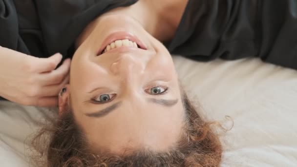 Wesoła Zabawna Młoda Ruda Kobieta Jedwabnym Szlafroku Odwraca Się Leżąc — Wideo stockowe