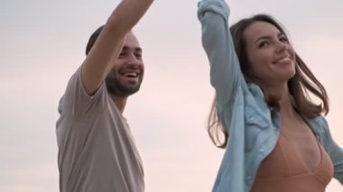 Dışarıda eğlenirken dans eden neşeli, sevimli genç çift.