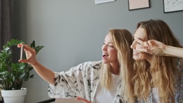 Dos Jóvenes Amigas Alegres Haciendo Selfie Teléfono Inteligente Mostrando Gesto — Vídeo de stock