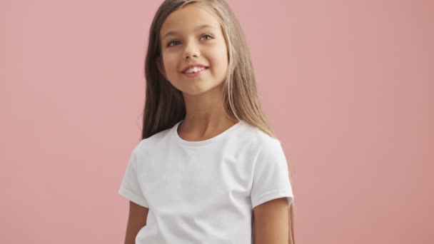 Feliz Niña Sonriendo Mirando Alrededor Fondo Rosa Aislado — Vídeos de Stock