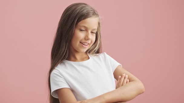 Menina feliz com as mãos cruzadas olhando para a câmera sorrindo fundo rosa — Vídeo de stock © Vadymvdrobot  