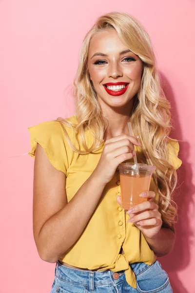 Imagem da mulher encantadora sorrindo e bebendo suco de copo de plástico — Fotografia de Stock