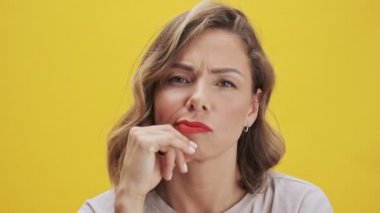Beautiful young woman with red lips gesturing like she finds out an idea over yellow background isolated