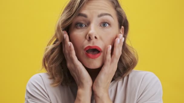 Pozytywna Młoda Kobieta Czerwonymi Ustami Pokazuje Zaskakujące Emocje Dotykając Policzków — Wideo stockowe