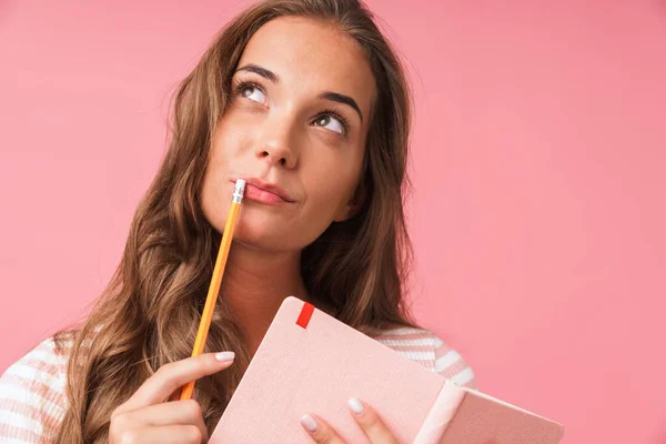 Image closeup of beautiful thinking woman wearing striped t-shirt looking upward while holding diary and pencil — Stock Photo, Image