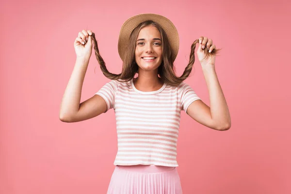 Imagen de una joven mujer feliz con sombrero de paja burlándose de su cabello mientras sonríe a la cámara — Foto de Stock